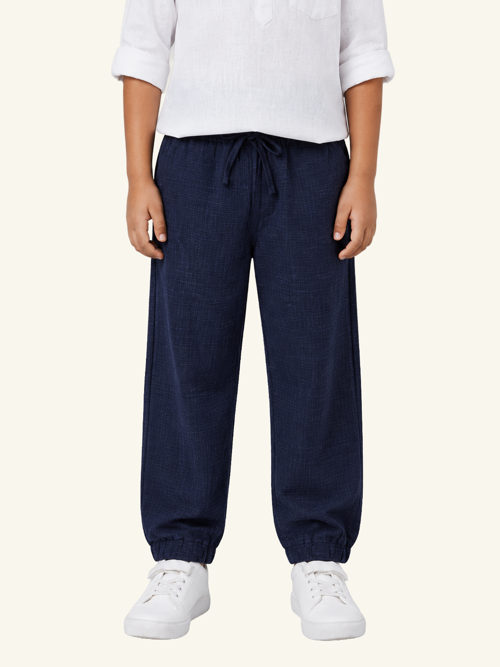 Person wearing navy blue pants and white shoes on a white background