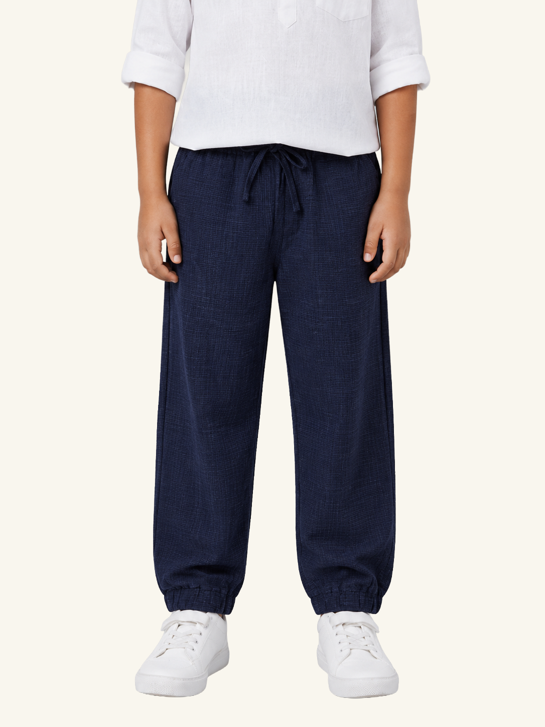 Person wearing navy blue pants and white shoes on a white background